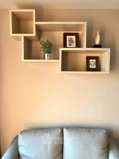 Modern living room with stylish wall-mounted wooden shelves and cozy gray sofa.