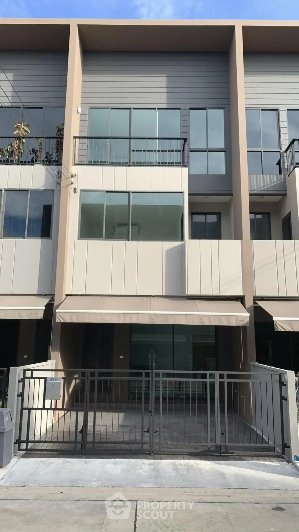 Modern townhouse exterior with sleek design and spacious balcony.