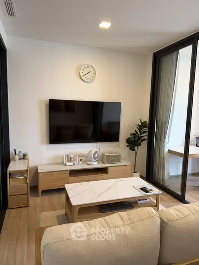 Modern living room with sleek TV setup and stylish furniture in a cozy apartment.