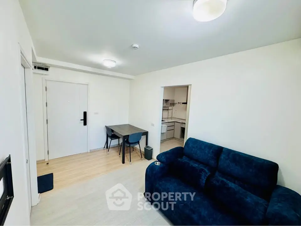 Modern living room with cozy blue sofa and dining area in open layout