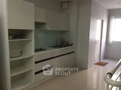 Modern minimalist kitchen with sleek white cabinets and glossy floor