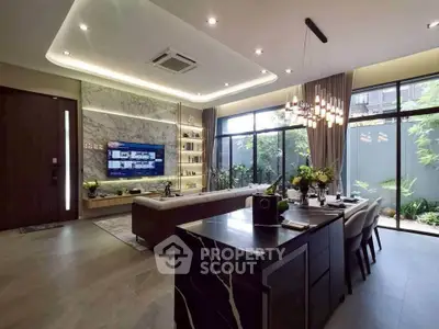 Luxurious modern living room with open kitchen and garden view, featuring elegant lighting and stylish decor.