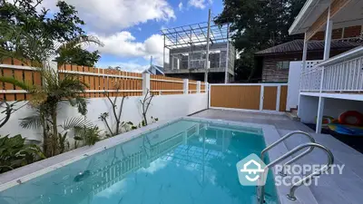 Charming backyard with a refreshing pool and modern fencing, perfect for relaxation and entertainment.