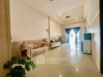 Spacious living room with modern decor and natural light, perfect for relaxation and entertaining.