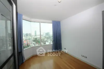 Spacious room with large window offering stunning city views, perfect for a modern urban lifestyle.