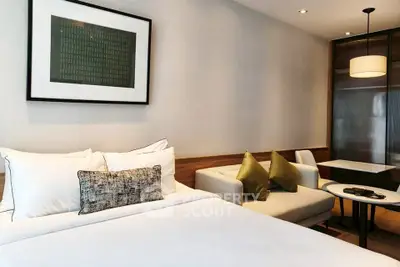 Modern bedroom with cozy seating area and stylish decor in a contemporary apartment.