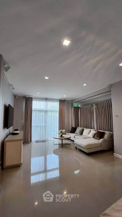 Spacious modern living room with elegant decor and large windows for natural light.