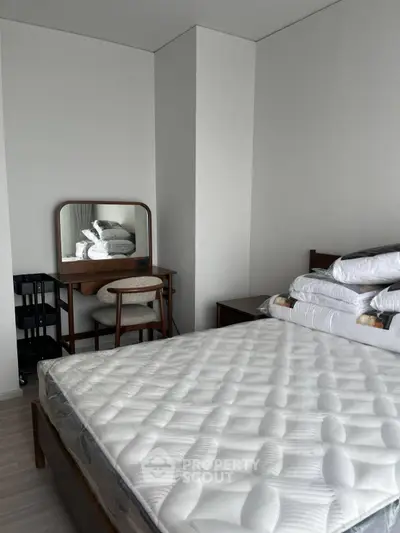 Modern bedroom with stylish furniture and comfortable mattress in a sleek apartment.