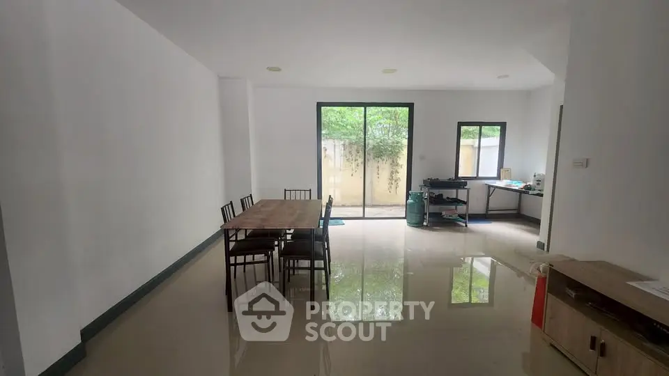 Spacious dining area with large windows and garden view, perfect for family gatherings.