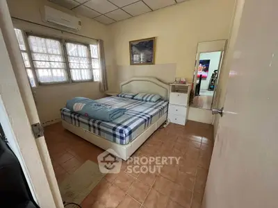 Cozy bedroom with tiled floor, air conditioning, and ample natural light from large windows.