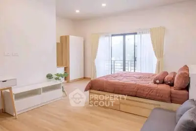 Spacious bedroom with modern decor and large window view