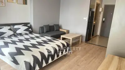 Modern studio apartment with stylish decor and open layout, featuring a cozy bed and sleek furniture.