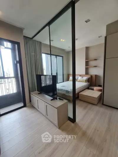 Modern studio apartment with glass partition and balcony view