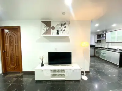 Modern living room with sleek TV stand and open kitchen layout