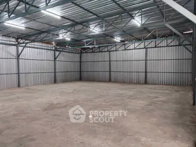 Spacious industrial warehouse with high ceilings and metal structure, ideal for storage or manufacturing.