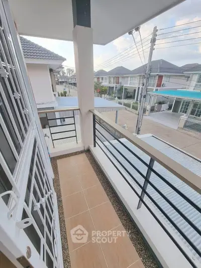 Charming balcony with modern railing and neighborhood view, perfect for relaxing outdoors.