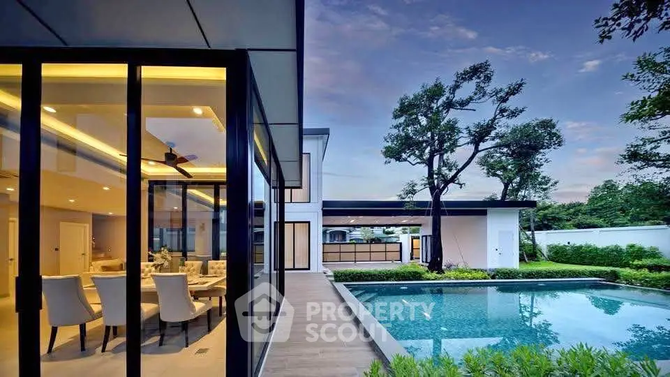 Luxurious modern home with stunning pool and elegant dining area, perfect for upscale living.