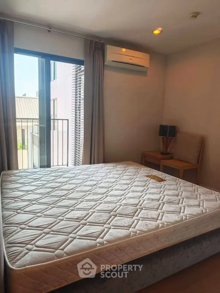 Cozy bedroom with large window and air conditioning in modern apartment.