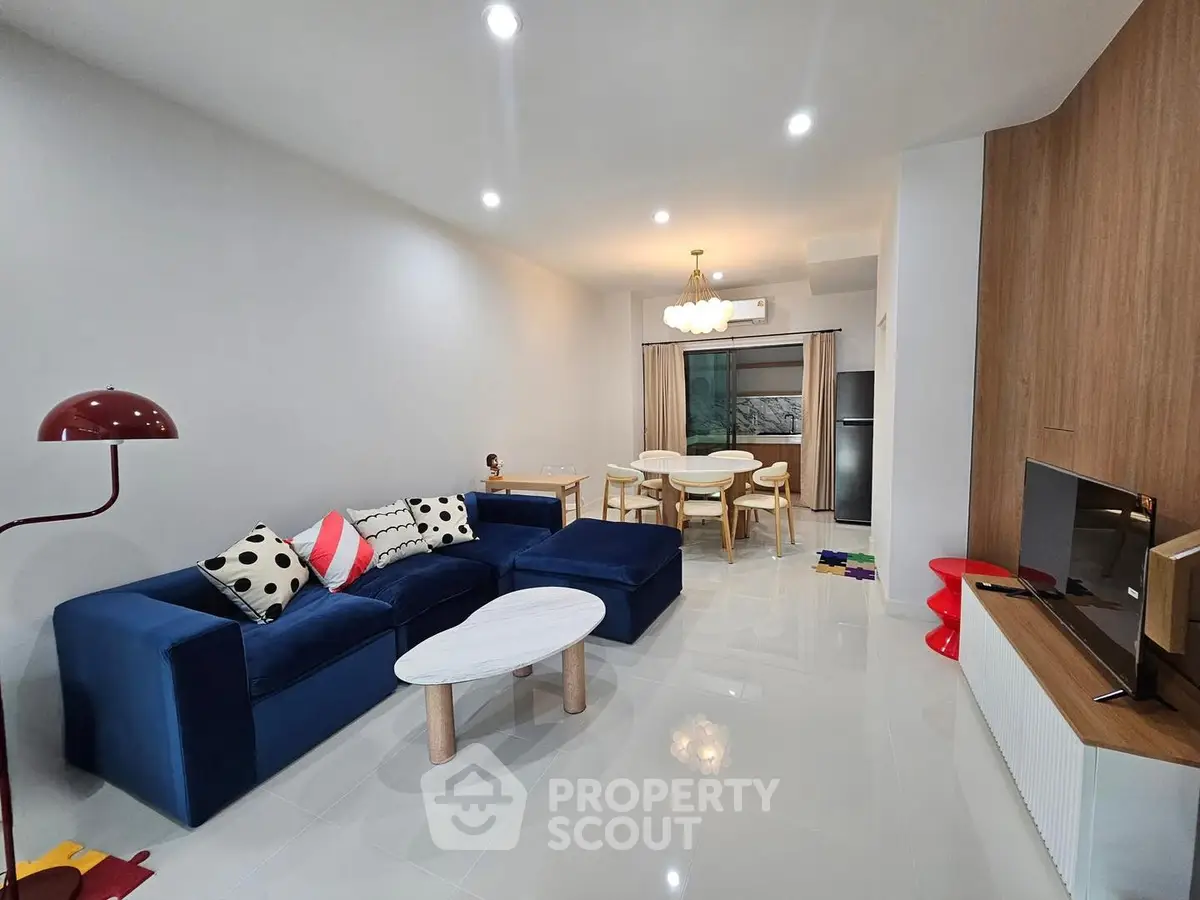 Modern living room with stylish blue sofa and open dining area