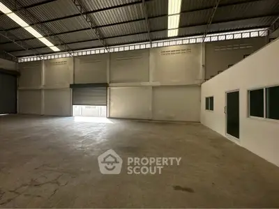 Spacious industrial warehouse with high ceilings and ample natural light.