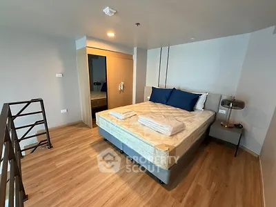 Modern bedroom with wooden flooring and stylish decor in a loft apartment.
