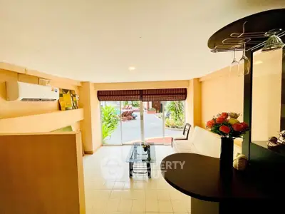 Spacious living room with modern decor and large windows opening to a garden view.
