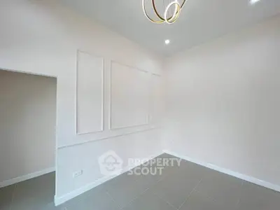 Spacious empty room with modern lighting and elegant wall paneling