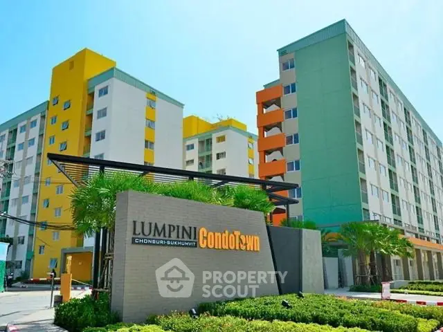 Modern condominium building with vibrant colors and lush landscaping at Lumpini Condo Town.