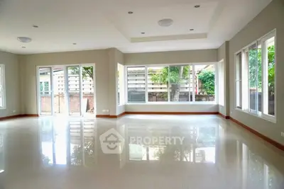 Spacious corner unit living room with large windows and garden view