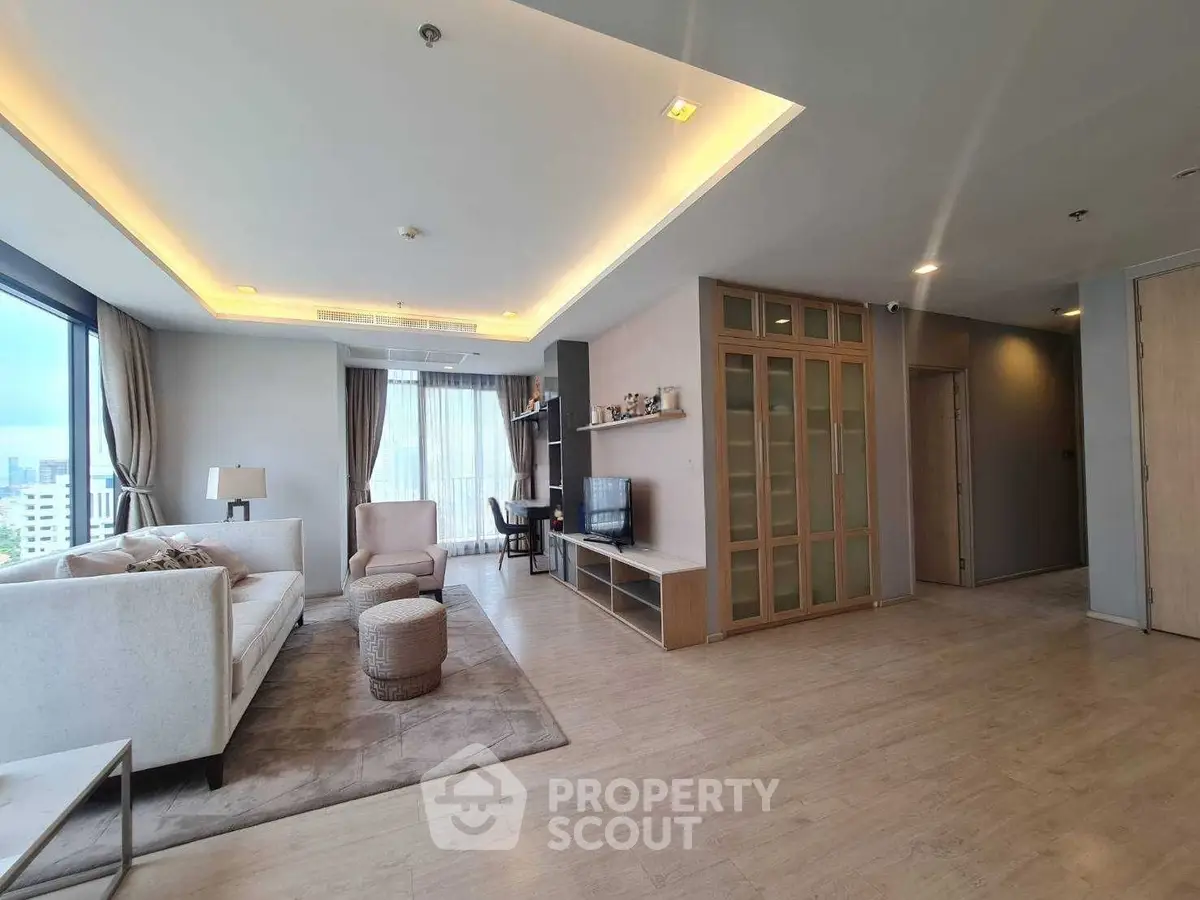 Spacious modern living room with city view, featuring elegant furniture and natural light.