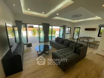 Spacious modern living room with large windows and stylish furniture, perfect for relaxation and entertainment.