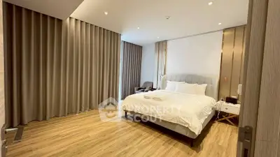 Spacious modern bedroom with elegant decor and wooden flooring