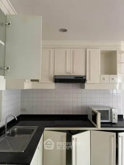 Modern kitchen with sleek black countertops and white cabinetry
