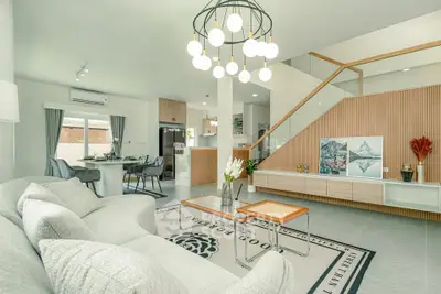 Modern open-plan living room with stylish decor and elegant staircase