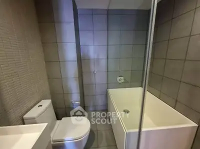 Modern bathroom with sleek design and bathtub in contemporary apartment.