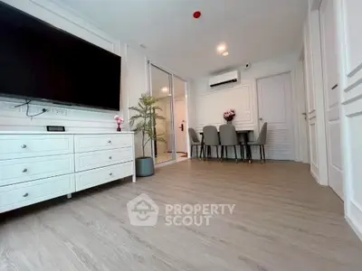 Modern living room with sleek flooring and elegant dining area, featuring a wall-mounted TV and stylish decor.