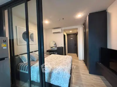Modern bedroom with glass partition, stylish decor, and cozy ambiance in a contemporary apartment.