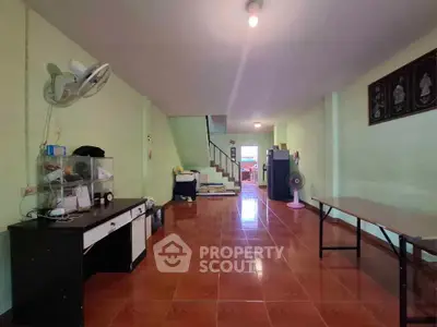 Spacious interior with tiled flooring and staircase, ideal for versatile living space.