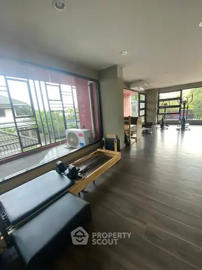 Spacious gym with modern equipment and large windows offering scenic views.