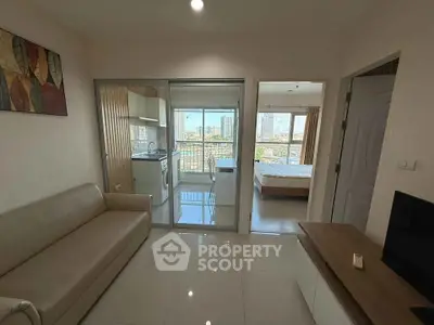 Modern apartment with open layout, featuring a cozy living room, compact kitchen, and bright bedroom with city views.