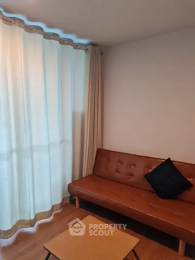 Cozy living room with modern brown sofa and stylish curtains, perfect for relaxation.