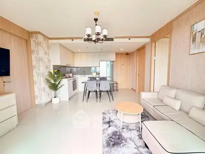 Modern open-plan living room with stylish kitchen and cozy seating area, perfect for entertaining.