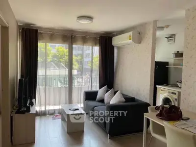 Modern living room with balcony, featuring sleek furniture and natural light, ideal for urban living.