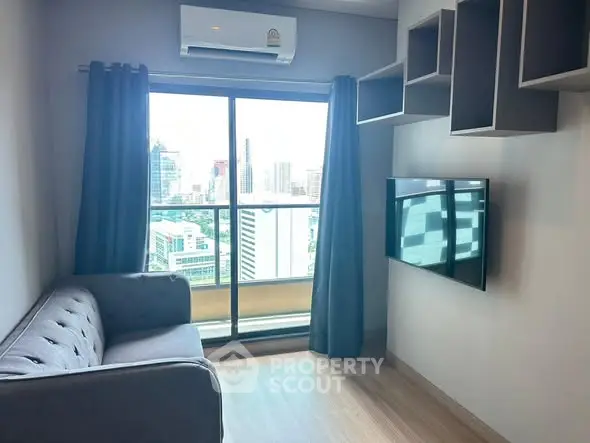 Modern living room with city view, featuring sleek sofa and wall-mounted TV.
