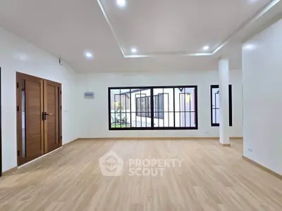 Spacious modern living room with wooden flooring and large windows