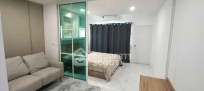 Modern bedroom with glass partition and cozy sofa in stylish apartment