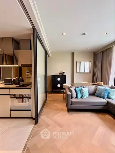 Modern living room with stylish kitchen and cozy sofa in open layout apartment.