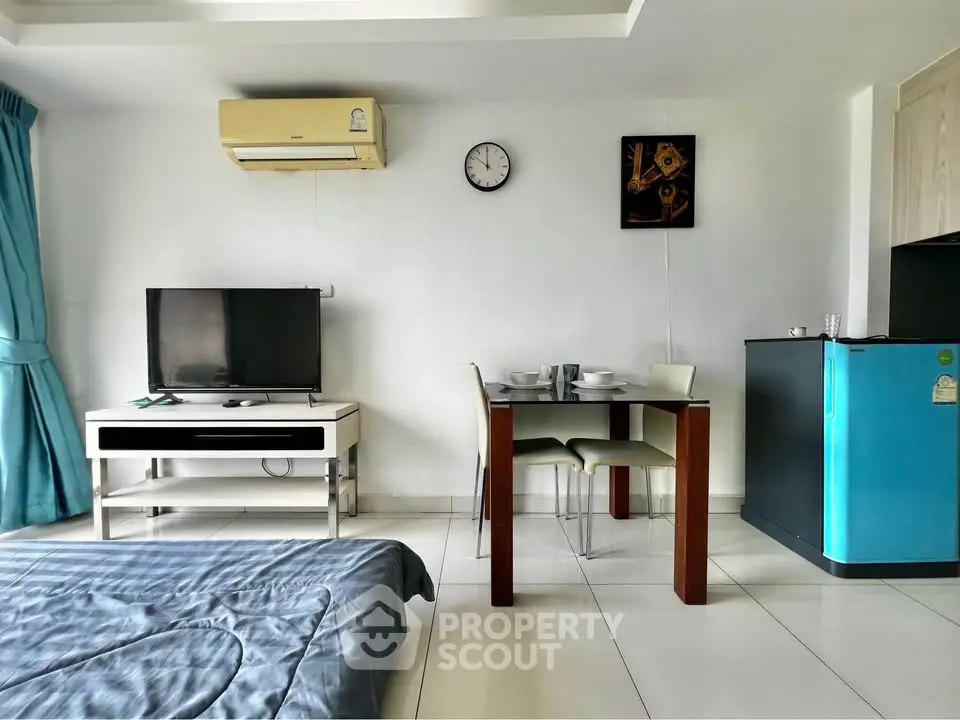 Modern studio apartment with sleek furniture and compact dining area, perfect for urban living.