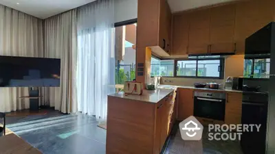 Modern kitchen with sleek wooden cabinetry, open layout, and large windows for natural light.