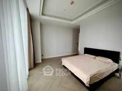 Spacious bedroom with elegant design and large windows for natural light.